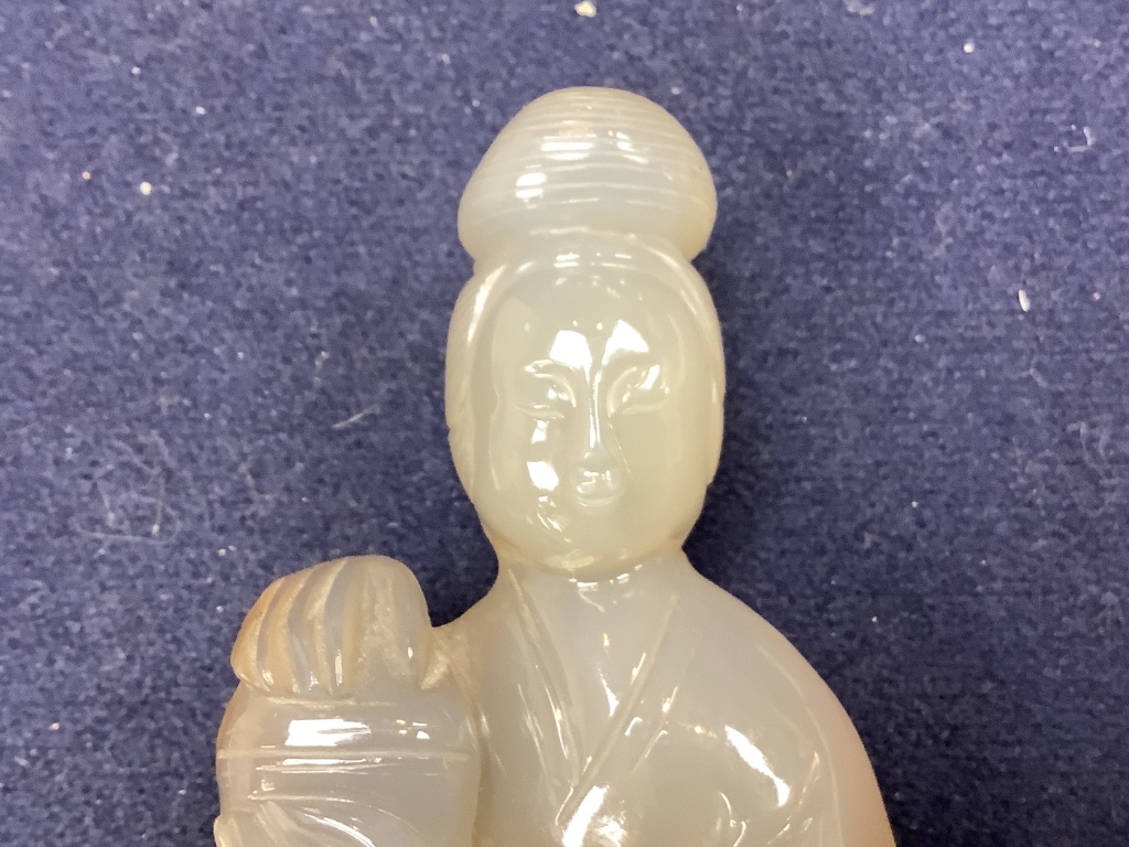 An early 20th century Chinese agate group of Guanyin and two boys, wood stand